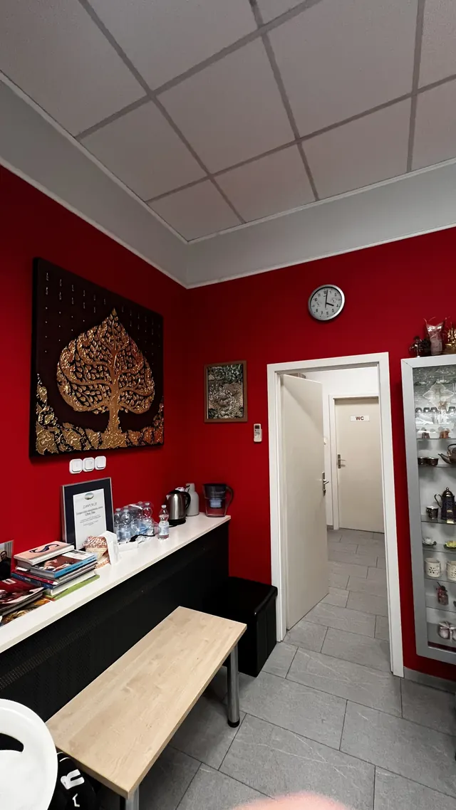 Waiting area with a red wall and a Thai painting